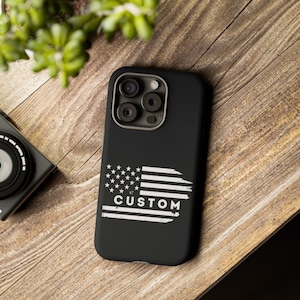 Könnte beinhalten: Schwarze Handyhülle mit einem abgenutzten amerikanischen Flaggen-Design und dem Wort "CUSTOM" in weißen Buchstaben.