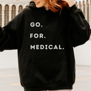 May include: Black hooded sweatshirt with the text "GO. FOR. MEDICAL." in white lettering.