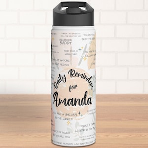 Könnte beinhalten: Eine weiße Wasserflasche aus Edelstahl mit schwarzem Deckel und einem abstrakten Design in Rosa und Weiß. Die Flasche trägt den Text "Daily Reminders for Amanda" und mehrere motivierende Zitate.