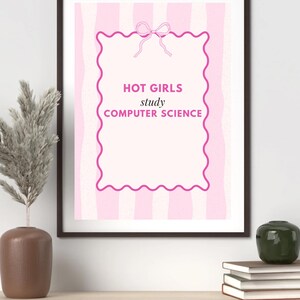 May include: A framed print with a pink and white striped background. The print features a pink scalloped border and the text "HOT GIRLS study COMPUTER SCIENCE" in pink. A decorative bow is at the top of the frame.