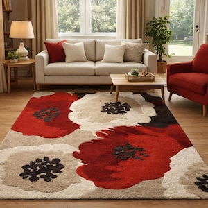 Puede incluir: Una alfombra grande con diseño floral en un salón. La alfombra presenta flores de gran tamaño en rojo, blanco y beige, con centros negros. La habitación incluye un sofá, un sillón y una mesa de centro, creando un ambiente acogedor.