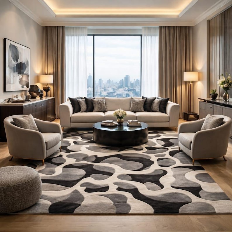 May include: A modern living room with a neutral color palette. Features a beige sofa, two armchairs, and a patterned rug in shades of gray and black. A round coffee table and a large window with a city view complete the space.