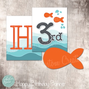 May include: A Happy Birthday banner with an ocean theme. The banner features orange letters and fish, with the number "3rd" in gray. The background has blue and white waves. An orange fish cutout is also included.