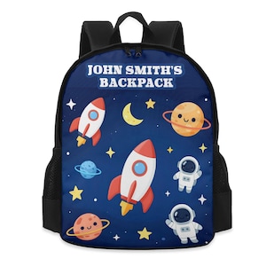May include: A navy blue backpack with a space-themed design. The backpack features rockets, planets, stars, and astronauts against a dark blue background. The text "JOHN SMITH'S BACKPACK" is printed at the top.