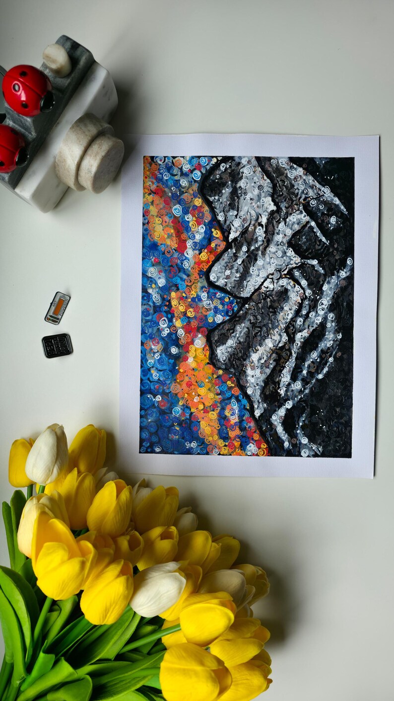 May include: Abstract art print featuring a profile in grayscale against a vibrant background of blue, orange, and yellow swirls. The artwork is on white paper, with a bouquet of yellow and white tulips in the foreground. Decorative ladybug and stone magnets are also present.