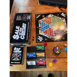 May include: A vintage "Sale of the Century" board game set. The box and game board are black with colorful accents. Includes game cards, a spinner, and a rules booklet. The game is based on the popular TV show.