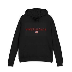 May include: Black hoodie with a front pocket and drawstring hood. The front features the text "#WETHEMOB" in red, with a small American flag graphic below the text. The hoodie is a solid black color.