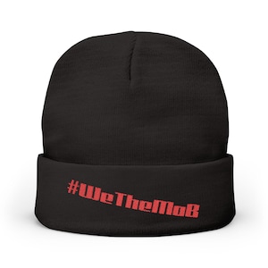 May include: Black beanie with a folded brim. The red text "#WeTheMoB" is printed across the brim. This winter hat is a stylish accessory for cold weather.