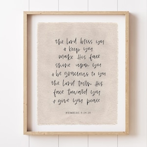 May include: A framed print with a light beige background and black script. The text reads "the lord bless you + keep you make His face shine upon you + be gracious to you the lord turn His face toward you + give you peace" with "NUMBERS 6:24-26" at the bottom.