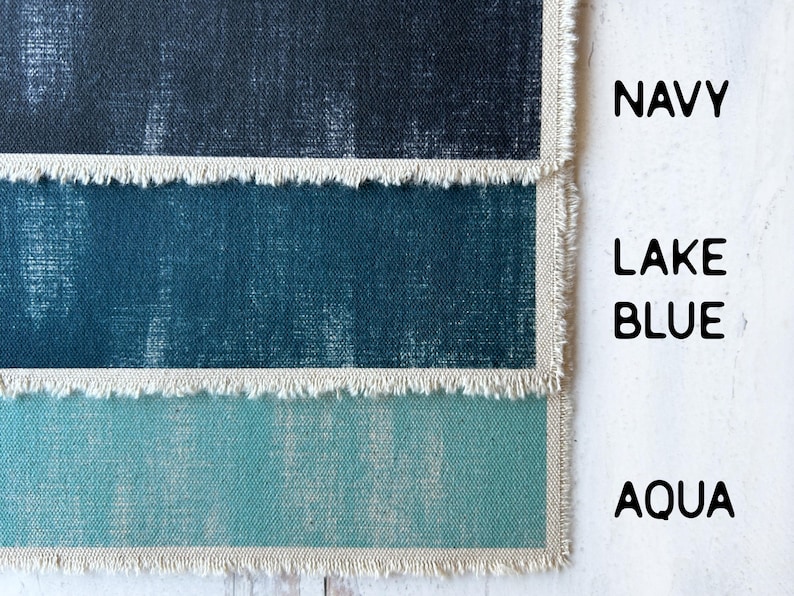 May include: Close-up of three fabric swatches in navy, lake blue, and aqua. Each swatch has a frayed edge and is labelled with its respective colour name in a bold font. The fabrics have a textured appearance.