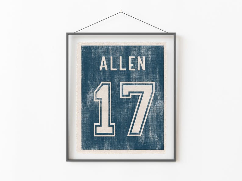 May include: Framed print featuring a distressed navy blue background with the name "ALLEN" and the number "17" in white. The print is encased in a black frame and hangs against a white wall.