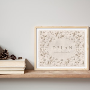 May include: A framed print with a floral design and the name "DYLAN michael" in a beige color.