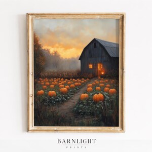 May include: A framed wall art print depicting a rustic wooden barn at dusk with glowing windows, situated behind a field of orange pumpkins. A dirt path leads through the pumpkin patch under a cloudy, golden-hued sunset sky in this landscape.