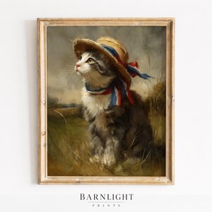 May include: A framed vintage print depicting a cat wearing a straw hat adorned with red, white, and blue ribbons. The cat is set in a field of long grass, against a soft, neutral backdrop. The print is from Barnlight Prints.