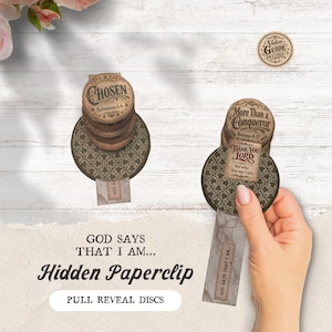 May include: Hidden paperclip discs with inspirational messages. The discs have text that reads "Chosen" and "More Than a Conqueror." The design includes a pull-out tab with the text "God Says That I Am..." and "Thank You Lord."