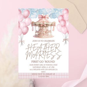 Può includere: Un invito rosa e bianco con un'illustrazione di giostra, palloncini rosa e il testo "Join us to celebrate Heather Marie's First Go 'Round". Include i dettagli dell'evento e le informazioni RSVP.