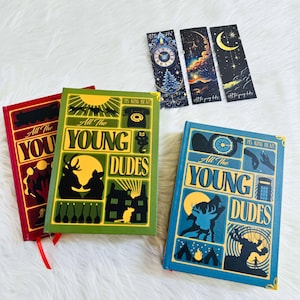 Może przedstawiać: Trzy książki w twardej oprawie i trzy zakładki. Książki są czerwone, zielone i niebieskie, każda z unikalną ilustrowaną okładką z napisem "All The Young Dudes". Zakładki przedstawiają wzory niebieskie i zegarowe. Czerwone wstążki są przymocowane do książek.