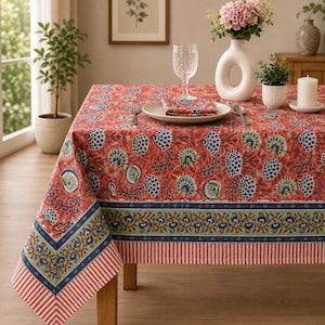 May include: A rectangular tablecloth featuring a vibrant red base with a repeating blue and green floral pattern. The border includes a decorative band of blue and green floral motifs, finished with a red and white vertical striped edge trim.