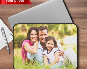 May include: Laptop sleeve featuring a family portrait in a grassy field. The image shows a smiling woman in a pink shirt, a man in a blue shirt, and a young girl. The text "your photo" is on a red banner.