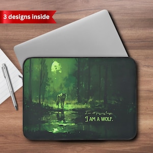 May include: Laptop sleeve featuring a wolf standing in a forest with a full moon. The artwork is predominantly green and black, with the text "I AM A WOLF." A red banner reads "3 designs inside."