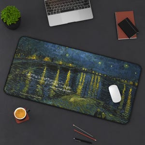May include: A rectangular desk mat featuring Vincent van Gogh's "Starry Night Over the Rhone" painting. The mat has a dark blue and yellow color scheme, with a quote and the artist's name printed on it. A white computer mouse rests on the mat.