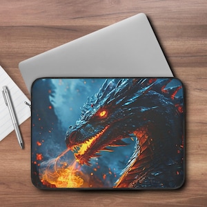 May include: Laptop sleeve featuring a detailed illustration of a black dragon breathing fire. The dragon has glowing orange eyes and is set against a blue and orange background. The sleeve is black and rectangular, designed to fit a laptop.