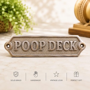 Könnte beinhalten: Rechteckiges, bronzefarbenes Schild mit den Worten "POOP DECK" in erhabenen Großbuchstaben. Das Schild hat eine strukturierte Oberfläche und abgerundete Kanten mit Löchern zur Befestigung. Aus massivem Messing gefertigt, hat es einen Vintage-Look.