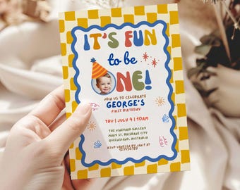 May include: A colorful invitation card with a yellow checkered border and blue wavy trim. The text "IT'S FUN to be ONE!" is displayed in playful fonts, with a photo of a baby wearing a party hat. The invitation is for George's first birthday.