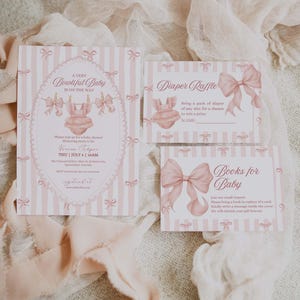 May include: Pink baby shower invitations with a striped background and bow accents. The main invitation reads "A Very Bowtiful Baby Is On The Way." Additional cards include "Diaper Raffle" and "Books for Baby."