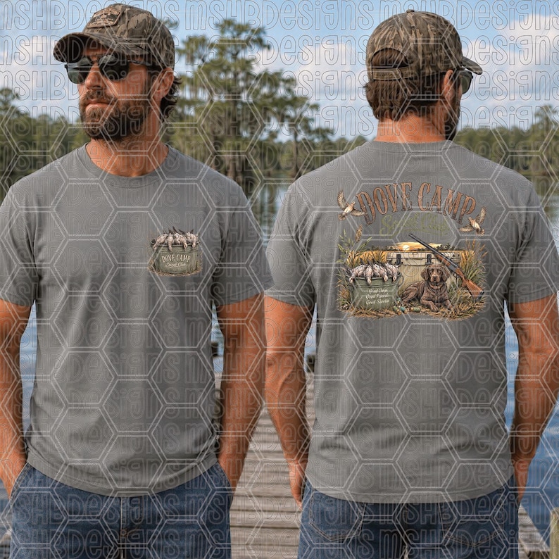 May include: A grey t-shirt featuring a small graphic on the front left chest and a larger graphic on the back. The back design shows a hunting dog, a shotgun, and a bucket of ducks with the text Dove Camp, with a similar bucket design on the front.