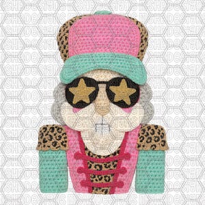 Może przedstawiać: Kapryśny, szydełkowy dziadek do orzechów z różową czapką, turkusowym daszkiem i okularami w kształcie gwiazd. Postać ma różową kurtkę z akcentami w panterkę i turkusowymi rękawami. Zabawny i świąteczny design.