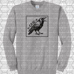 May include: A grey sweatshirt with a black raven design in a black square. The raven has an open beak, and the text "F-CAW-F" is above it. The sweatshirt has a crew neck and long sleeves, suitable for cooler weather.