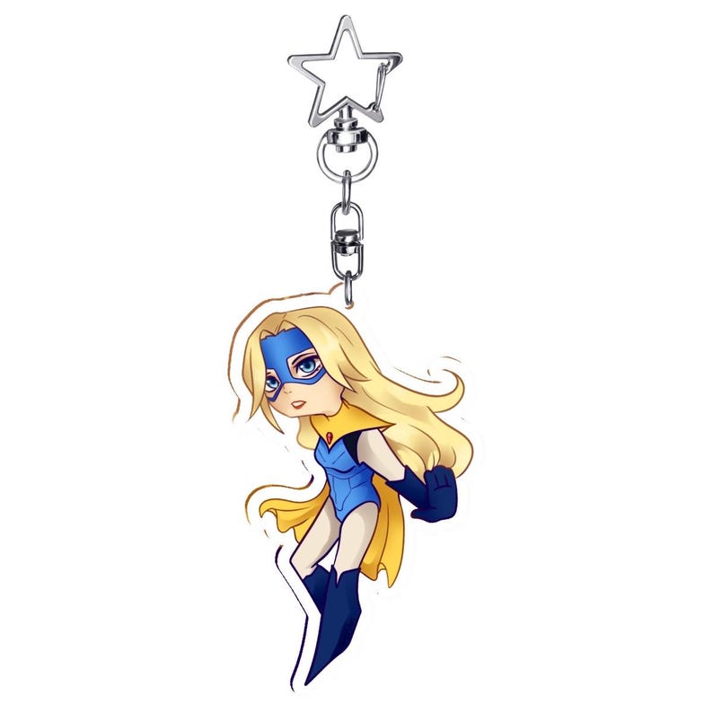 May include: A keychain featuring a cartoon superheroine with long blonde hair, a blue mask, and a blue and yellow costume. The keychain has a silver star-shaped clasp and a chain.