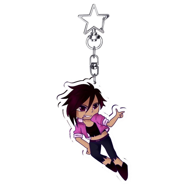 May include: A cartoon keychain featuring a character with dark hair, wearing a pink jacket, black top, and dark pants. The keychain has a silver star-shaped clasp and a silver chain. The character is pointing with one hand and has a confident expression.