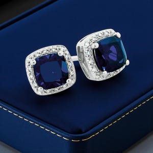 Pendientes de botón con halo de diamantes y zafiros azules en forma de cojín, en oro blanco, amarillo o plata de 14k. Un accesorio llamativo o ideal para compromiso. Joyería fina.