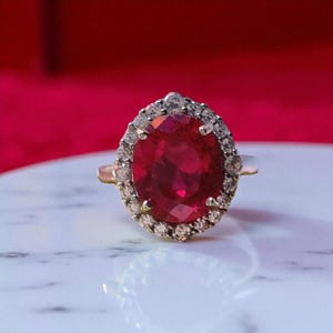 Anel com rubi oval grande e halo de diamantes em ouro 14k, anel de coquetel vintage, anel de rubi luxuoso e marcante, joia para noivado ou aniversário.
