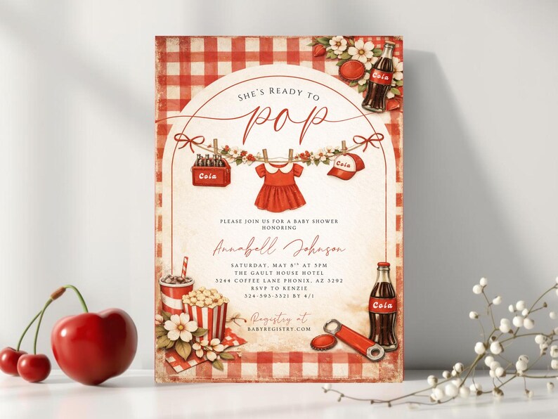 May include: A vintage-style baby shower invitation with a red and white checkered background. The invitation features the text "She's Ready to Pop" and includes illustrations of a baby dress, cola bottles, and popcorn. The invitation also includes the name Annabell Johnson.
