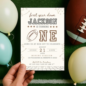 May include: A football-themed invitation card held by a hand, with the text "first year down JACKSON IS TURNING ONE." The invitation includes details for a first birthday celebration, with a football graphic and the date August 21.