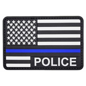 May include: A rectangular patch featuring a stylized American flag design in black and white. The flag includes a horizontal blue stripe across the center and the word POLICE printed in white capital letters on the bottom right section.