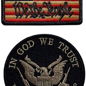 May include: A rectangular embroidered patch featuring a stylized American flag with the text 1776 and We the People, paired with a circular black embroidered patch displaying an eagle emblem, the text IN GOD WE TRUST, and THE GUNS ARE JUST BACKUP.