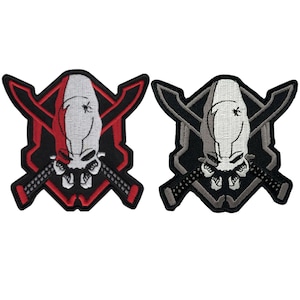 May include: Two embroidered patches featuring a skull design with crossed swords. One patch has a red and black color scheme, while the other is black and gray. The skull is white with a small insect graphic.