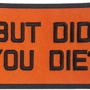 May include: A rectangular embroidered patch with a vibrant orange background and a thick black border. The text BUT DID YOU DIE? is stitched in bold, black, sans-serif capital letters across the center of the patch, creating a high-contrast design.