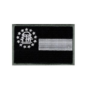 May include: A rectangular embroidered patch featuring a black background with a white horizontal stripe on the right side. On the left, a white circular arrangement of thirteen stars surrounds a central white arch and pillar emblem design.