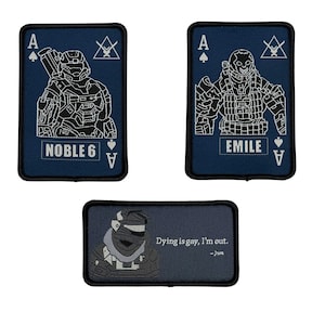 May include: Three navy blue embroidered patches. Two are shaped like playing cards, featuring white illustrations of armored figures and the text "NOBLE 6" and "EMILE". The third patch has a figure and the text "Dying is gay, I'm out."