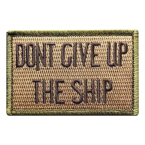 Könnte beinhalten: Ein rechteckiger bestickter Aufnäher mit beigem Hintergrund und dunkelolivgrünem Rand. Der Text DONT GIVE UP THE SHIP ist mittig in dunkelbraunem Garn in einer fetten, serifenlosen Schrift gestickt und weist eine strukturierte Webart auf.