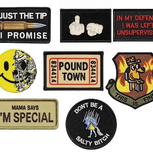 May include: A collection of eight embroidered patches featuring various designs including a bullet with text, hand gestures, text-based slogans, a half-smiley half-skull face, a ticket graphic, a dog in flames, and a figure holding a salt shaker.