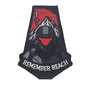 Könnte beinhalten: Schwarzer, gestickter Aufnäher mit einem futuristischen Soldatenhelm mit rotem Visier, vor einer roten und grauen Berglandschaft. Der Text "REMEMBER REACH" ist am unteren Rand des Aufnähers angebracht.