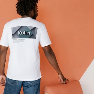 Peut inclure: T-shirt blanc avec le mot "Kotlin" dans un motif géométrique au dos. Le texte "Kotlin - Geometry" est également imprimé en dessous. La personne porte un jean bleu. Fond orange et blanc.