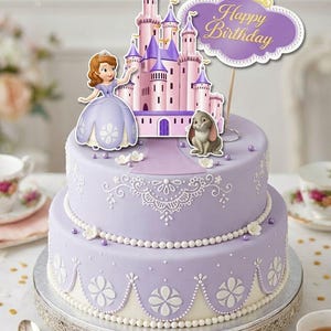 Puede incluir: Un pastel de lavanda de dos niveles con decoraciones florales y de cuentas blancas. El pastel está cubierto con una figura de princesa, un castillo, un conejito y un letrero morado que dice "Happy Birthday" en letras doradas.