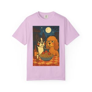 Puede incluir: Camiseta de color lila claro con una ilustraci&oacute;n de dibujos animados de dos perros compartiendo espaguetis. La escena incluye una botella de vino, una vela encendida y una luna llena. Los perros tienen expresiones de mal humor.
